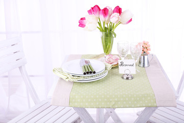 New table and chairs with place settings on light background