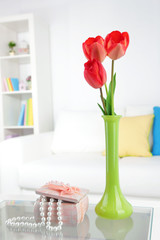 Beautiful spring flowers in vase on home interior background