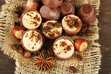 Fototapeta na wymiar Tasty chocolate candies with coffee beans and nuts