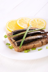 Sprats sandwich on white plate