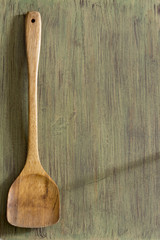 Wooden kitchenware on green background