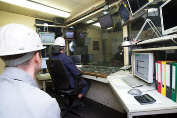 Arbeiter in Steuerzentrale im Rohrwerk // operation centre