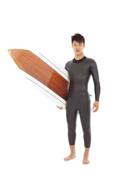 Surfing Man Wore Wet Suit And Holding Surfing Board