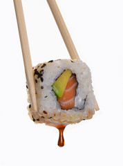 Sujetando sushi roll con salsa de soya.Comida japonesa.