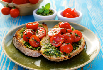 Bruschetta with fresh cherry tomatoes and aromatic herb pesto