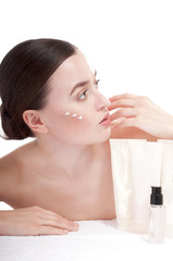 Obraz na płótnie Canvas Sensual woman applying cosmetic cream treatment on her face.