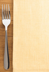fork and napkin on wood