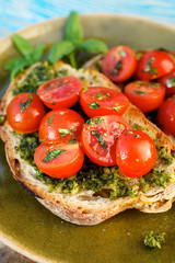 Bruschetta with fresh cherry tomatoes and aromatic herb pesto