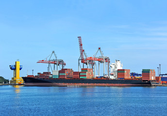 Fototapeta premium Container stack and ship under crane bridge