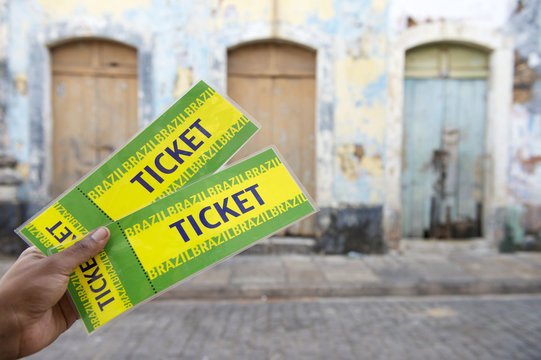 Brazilian Hand Holding Two Tickets on the Street