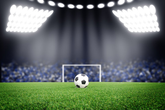 Soccer ball on field in stadium at night