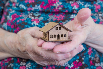 a small house on hands of a senior woman