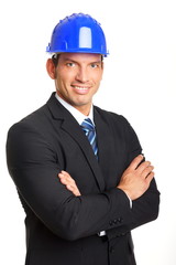 Businessman in suit standing with a protective helmet closeup