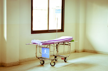 Empty stretcher in a hospital by glass windows..