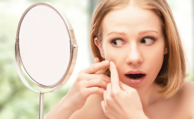 beautiful healthy woman  frightened saw in the mirror acne and w