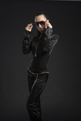 Pretty Caucasian woman in black leather catsuit