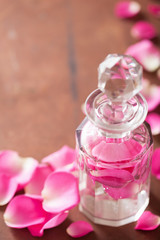 Obraz na płótnie Canvas perfume bottle and pink rose flowers. spa aromatherapy