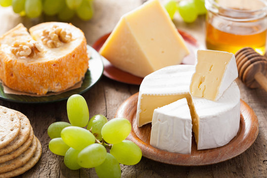various types of cheese with grapes, honey and nuts