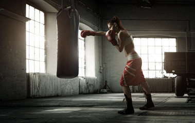 Young woman boxing workout in an old building - obrazy, fototapety, plakaty
