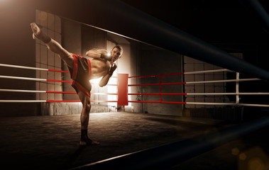 Young  man kickboxing in the Arena - obrazy, fototapety, plakaty