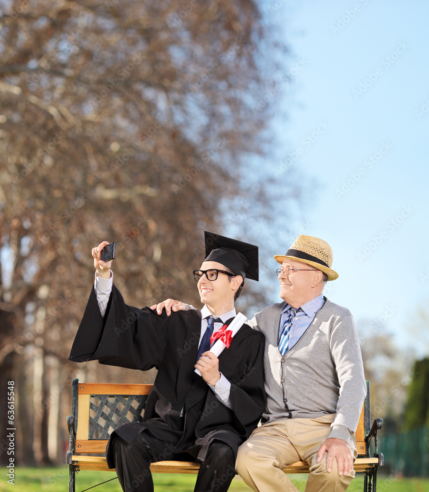 Canvas Prints Male student and his father taking selfie in park