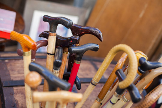 Assorted canes and walking sticks in a wooden holder
