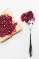 Slice of toast with cherry jam and spoon