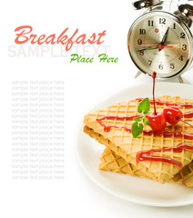 waffles with cherry topping and alarm clock isolated on white