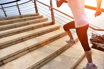 healthy lifestyle sports woman running on stone stairs seaside
