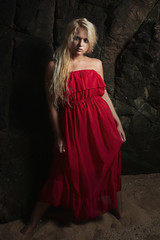 Beautiful blond woman in Red Dress.near the rock.Summer