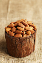 Almonds in bowl on sackcloth background
