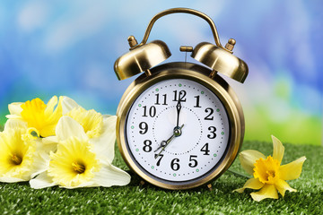 Alarm clock on green grass, on nature background