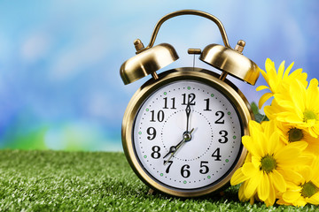 Alarm clock on green grass, on nature background