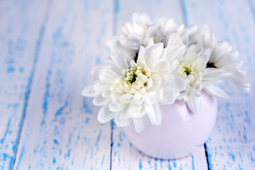Beautiful chrysanthemum flowers in vase on wooden table