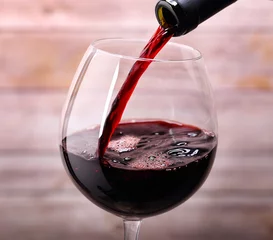 Cercles muraux Alcool Verser le vin rouge dans le verre