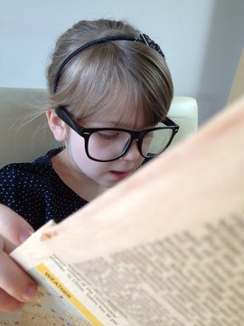 little girl reading newspaper