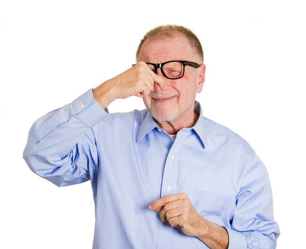 Something stinks. Portrait older man pinching his nose