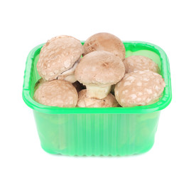 Brown champignons in plastic box.