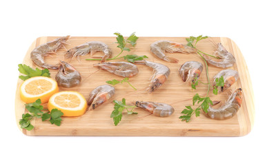 Shrimps and lemon slices on cutting board.