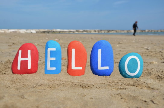 Hello on colourful stones and beach background