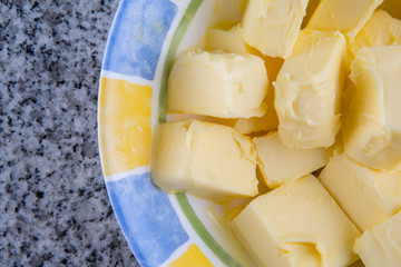 A group of melting butter in a bowl over granite surface