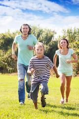 Happy family with  child  running  at  park