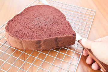 Cutting chocolate cake on layers.