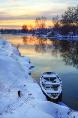Foto op Canvas Winterzonsondergang op de rivier met een boot © Yuriy Kirsanov