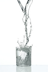 Fresh flow of water splashing in a tranparent glass