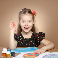 Little girl draws paints in kindergarten