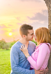 Beautiful couple embracing on date in sunset