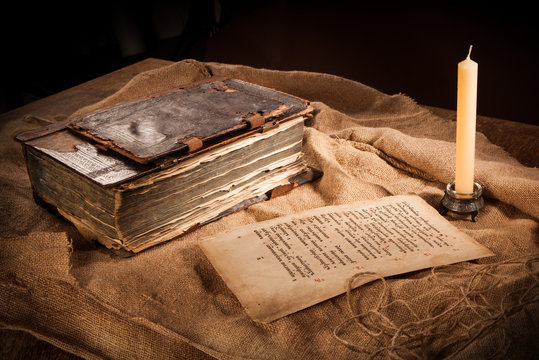 antique book, paper and candle