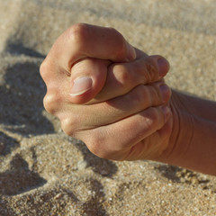 Woman hand and sand.