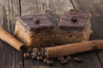 Two chocolate tarts with coffee beans and cinnamon sticks